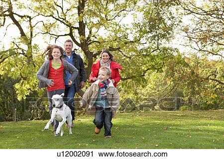 Young Family Outdoors Walking Through Park With Dog View Large Photo Image Stock Image - Young Family Outdoors Walking Through Park With Dog. Fotosearch