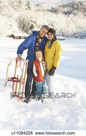 Young Family Standing In Snowy Landscape Holding Sledge View Large Photo Image Stock Photo - Young Family Standing In Snowy Landscape Holding Sledge. Fotosearch