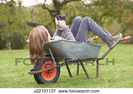 Young Girl Laying Wheelbarrow Using Smart Mobile Phone View Large Photo Image Stock Photo - Young Girl Laying Wheelbarrow Using Smart Mobile Phone. Fotosearch