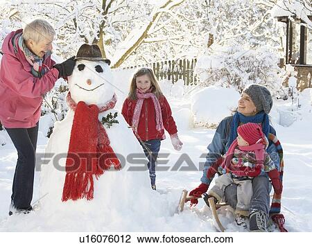 Young Girl With Grandmother And Mother Building Snowman In Garden View Large Photo Image Stock Image - Young Girl With Grandmother And Mother Building Snowman In Garden. Fotosearch