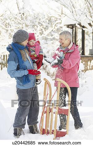 Stock Photography - Young Girl With Grandmother And Mother Holding Sledge In Garden. Fotosearch