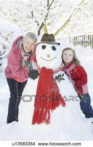 Young Girl With Grandmother Building Snowman In Garden View Large Photo Image Picture - Young Girl With Grandmother Building Snowman In Garden. Fotosearch