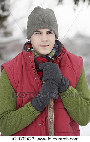 Stock Image - Young Man Clearing Snow From Drive. Fotosearch