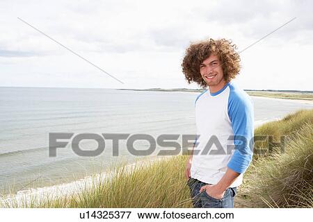 Young Man Standing In Sand Dunes View Large Photo Image Stock Photo - Young Man Standing In Sand Dunes. Fotosearch