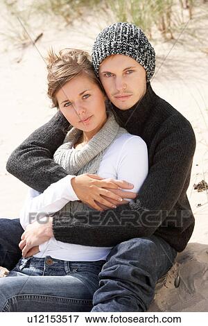 Stock Photo - Young Romantic Couple Relaxing On Beach Together. Fotosearch