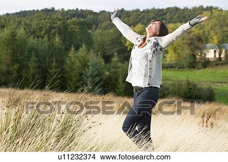 Picture - Young Woman Enjoying Freedom Outdoors in Autumn Landscape. Fotosearch