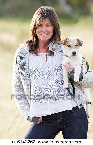 Young Woman Outdoors In Autumn Landscape Holding Dog View Large Photo Image Stock Image - Young Woman Outdoors In Autumn Landscape Holding Dog. Fotosearch