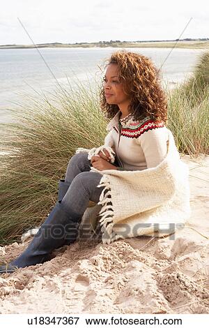 Young Woman Sitting In Sand Dunes Wrapped In Blanket View Large Photo Image Stock Photo - Young Woman Sitting In Sand Dunes Wrapped In Blanket. Fotosearch