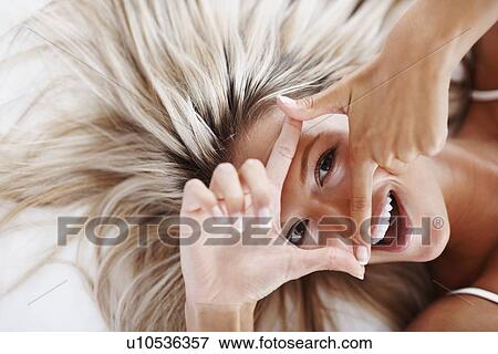 Stock Photo - Blonde woman lying on bed. Fotosearch