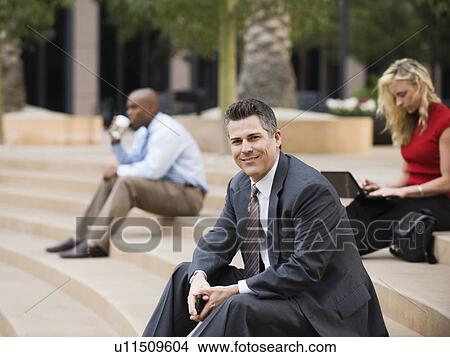 Picture - Business people sitting on outdoor steps. Fotosearch