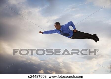 Stock Image - Businessman flying in the sky. Fotosearch