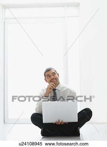 Stock Photography - Businessman holding laptop. Fotosearch