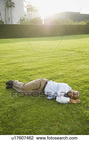Businessman napping on lawn View Large Photo Image Stock Image - Businessman napping on lawn. Fotosearch
