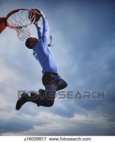 Stock Photo - Businessman playing basketball. Fotosearch