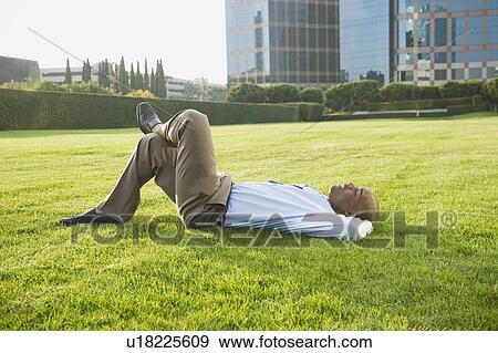 Stock Photo - Businessman relaxing on lawn. Fotosearch