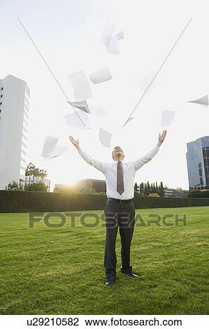 Stock Image - Businessman throwing papers in air. Fotosearch