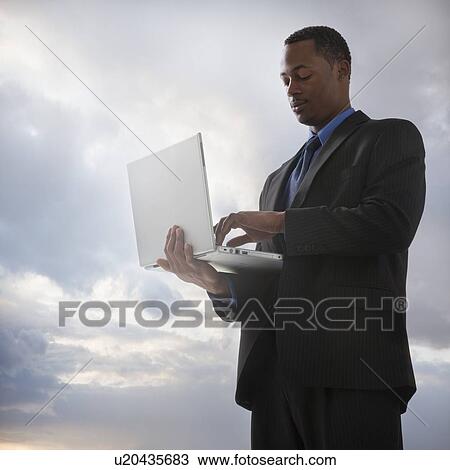 Stock Image - Businessman typing on a laptop computer. Fotosearch