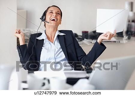 Businesswoman laughing while wearing headset View Large Photo Image Stock Photo - Businesswoman laughing while wearing headset. Fotosearch