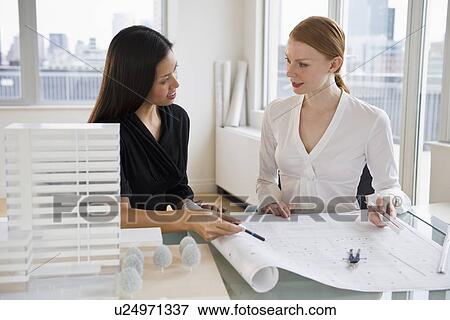 Stock Photo - Businesswomen looking at blueprints. Fotosearch