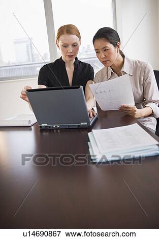 Stock Photo - Businesswomen working in conference room. Fotosearch