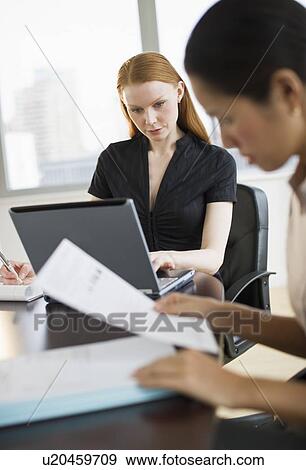 Stock Photo - Businesswomen working in conference room. Fotosearch
