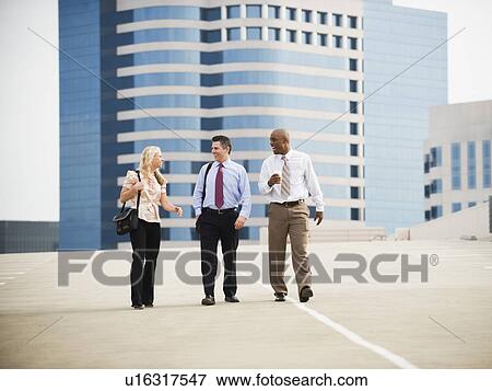 Co-workers walking in parking lot View Large Photo Image Stock Photo - Co-workers walking in parking lot. Fotosearch