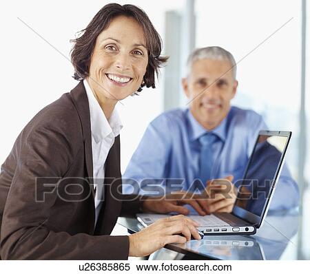Colleagues working on laptop View Large Photo Image Stock Photography - Colleagues working on laptop. Fotosearch