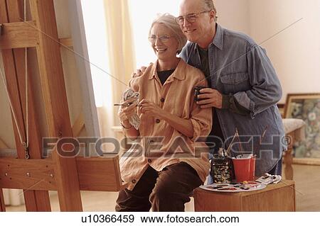 Stock Photo - Couple admiring woman's painting. Fotosearch