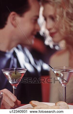 Couple drinking martinis in a restaurant View Large Photo Image Stock Image - Couple drinking martinis in a restaurant. Fotosearch