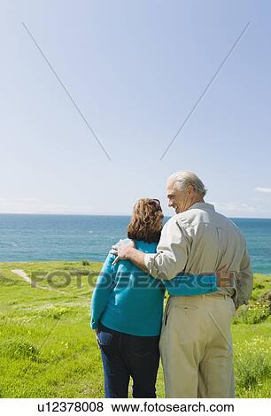 Couple looking at the ocean View Large Photo Image Stock Photo - Couple looking at the ocean. Fotosearch