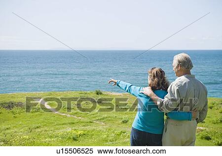 Couple looking at the ocean View Large Photo Image Stock Photography - Couple looking at the ocean. Fotosearch