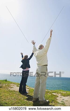 Stock Photo - Couple raising their arms. Fotosearch