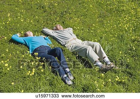 Couple relaxing in meadow View Large Photo Image Stock Image - Couple relaxing in meadow. Fotosearch