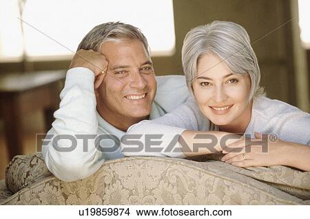 Picture - Couple relaxing on couch together. Fotosearch