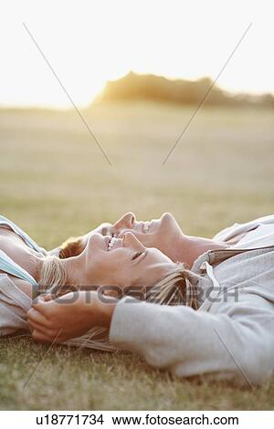 Couple relaxing on the grass View Large Photo Image Picture - Couple relaxing on the grass. Fotosearch