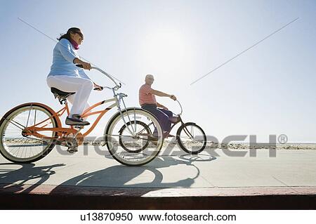 Couple riding bicycles View Large Photo Image Stock Image - Couple riding bicycles. Fotosearch