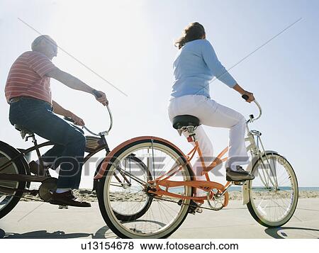 Couple riding bicycles View Large Photo Image Stock Photo - Couple riding bicycles. Fotosearch