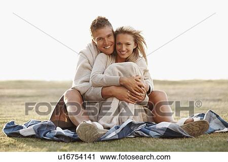 Couple sitting together in a field View Large Photo Image Stock Image - Couple sitting together in a field. Fotosearch