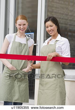 Stock Photography - Cutting red ribbon at opening ceremony. Fotosearch