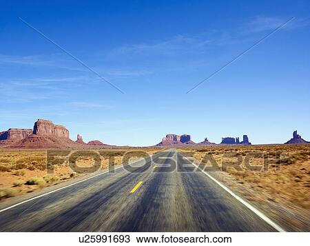 Stock Image - Desolate road through the desert. Fotosearch