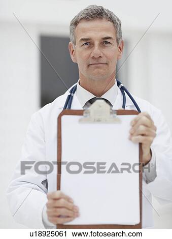 Stock Image - Doctor holding clipboard. Fotosearch