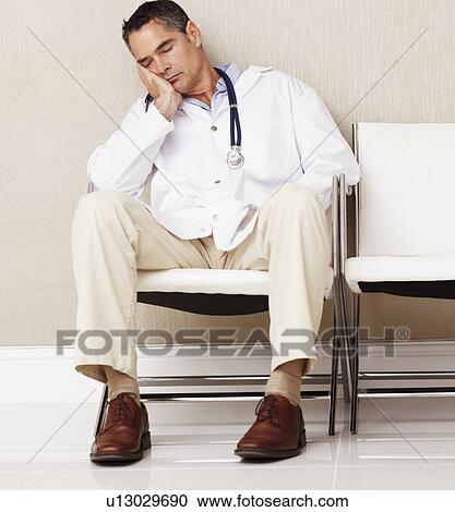 Stock Image - Doctor sitting in waiting room. Fotosearch