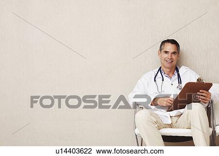 Doctor sitting in waiting room View Large Photo Image Stock Image - Doctor sitting in waiting room. Fotosearch
