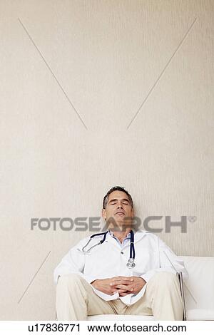 Stock Image - Doctor sitting in waiting room. Fotosearch