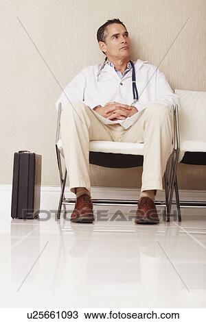 Stock Image - Doctor sitting in waiting room. Fotosearch
