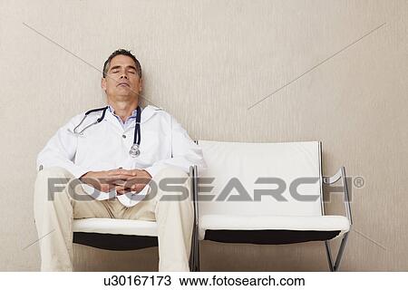 Stock Image - Doctor sitting in waiting room. Fotosearch