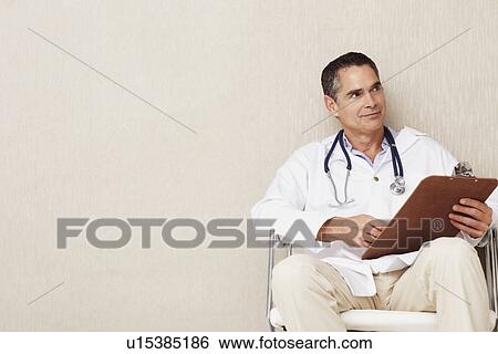 Stock Photograph - Doctor sitting in waiting room. Fotosearch