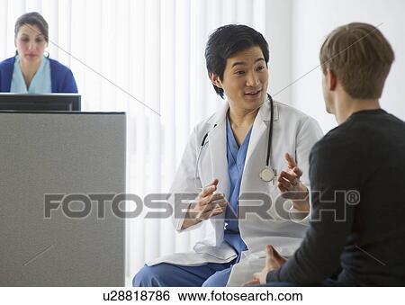 Stock Photograph - Doctor talking to patient in waiting room. Fotosearch