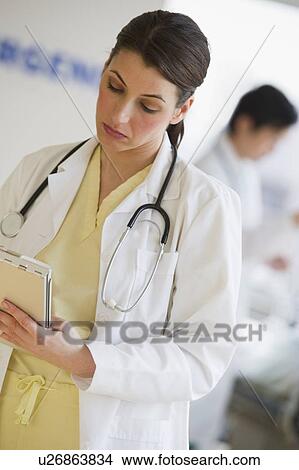 Doctor writing on chart View Large Photo Image Picture - Doctor writing on chart. Fotosearch