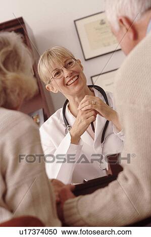 Stock Image - Elderly couple talking to doctor. Fotosearch